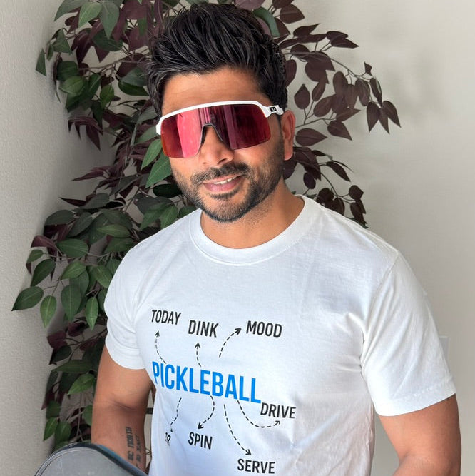 Man wearing the UnbrandT Picklebrain T-shirt while relaxing outdoors in Southern California. Premium cotton pickleball apparel featuring a playful Picklebrain graphic for players who live and breathe the game. Casual lifestyle clothing inspired by pickleball, beach days, coffee runs, and everyday comfort.